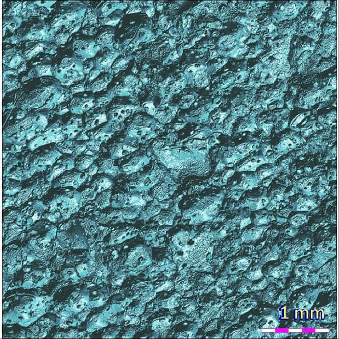2D photo simulation of the blue climbing grip surface showing pores, roughness, and morphology under artificial lighting.