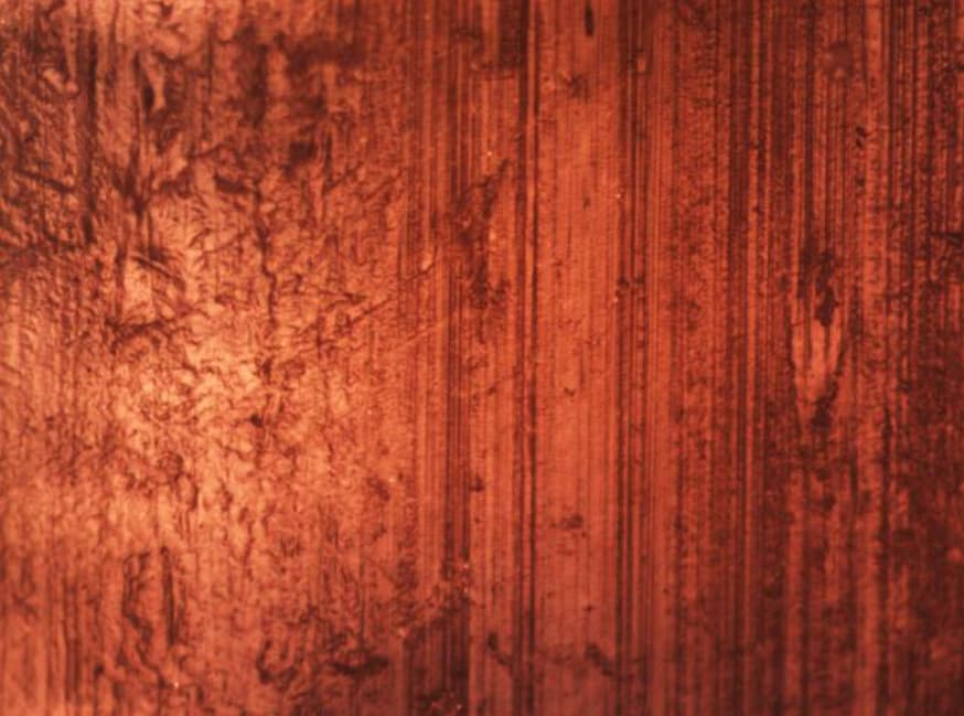Microscope image at 400x magnification showing severe wear grooves on silicone pacing lead surface